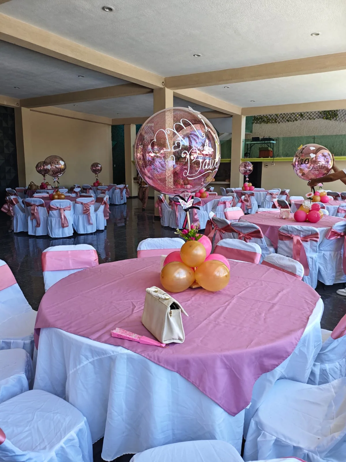 Montaje rosa con globos en mesas